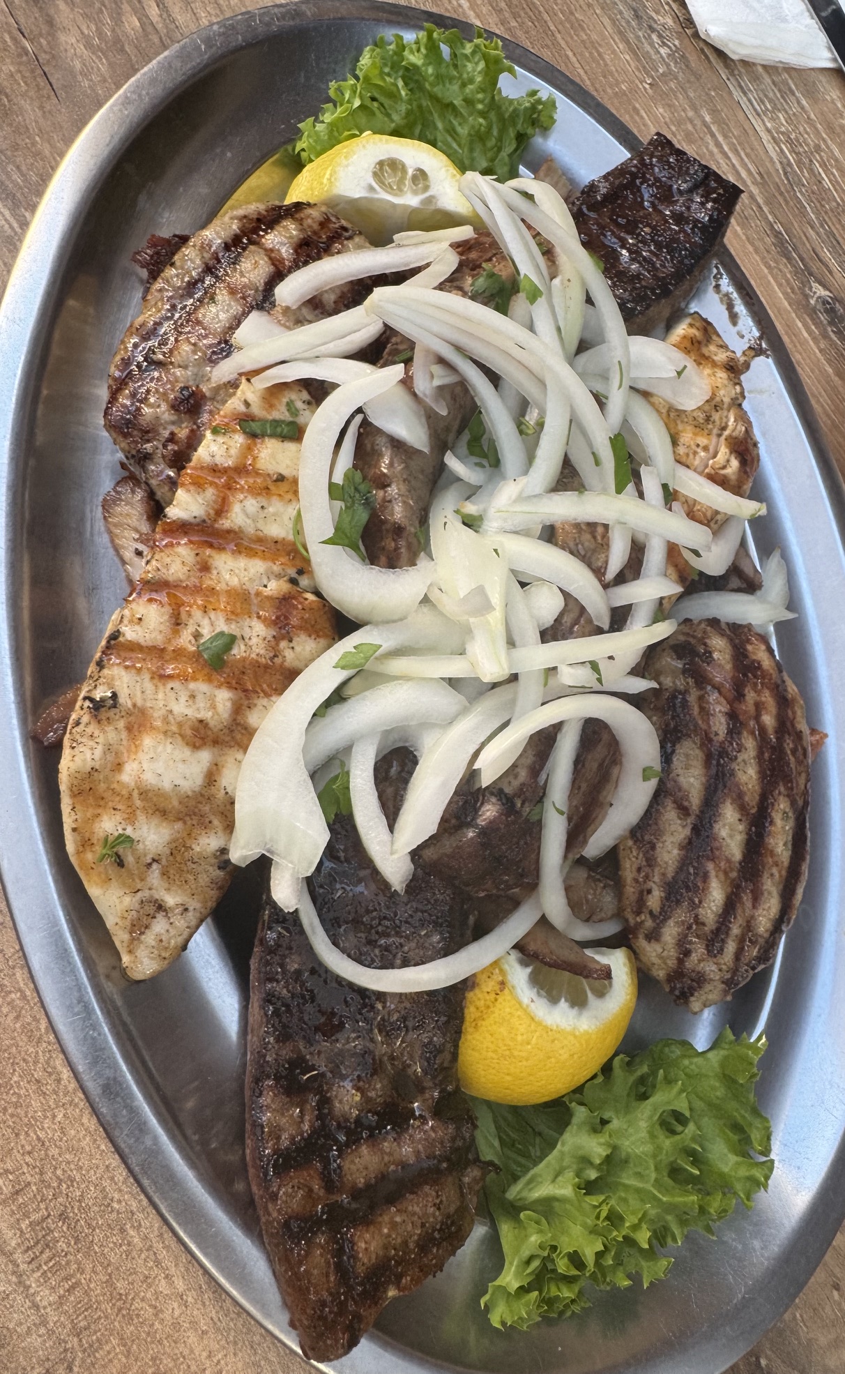 Gemischte Grillplatte mit Fleisch, Zwiebeln und Zitrone